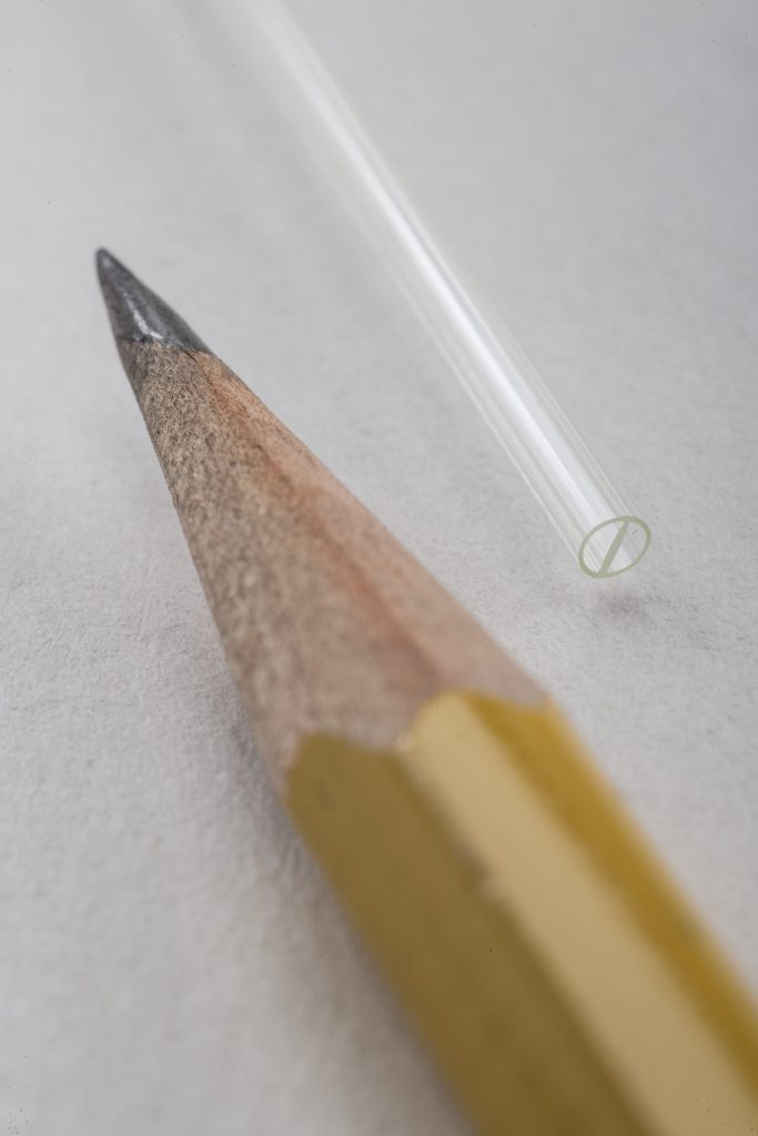 multi-lumen tube with double D design next to pencil tip for size comparison