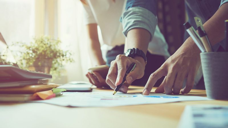 two designers collaborating over a design on paper